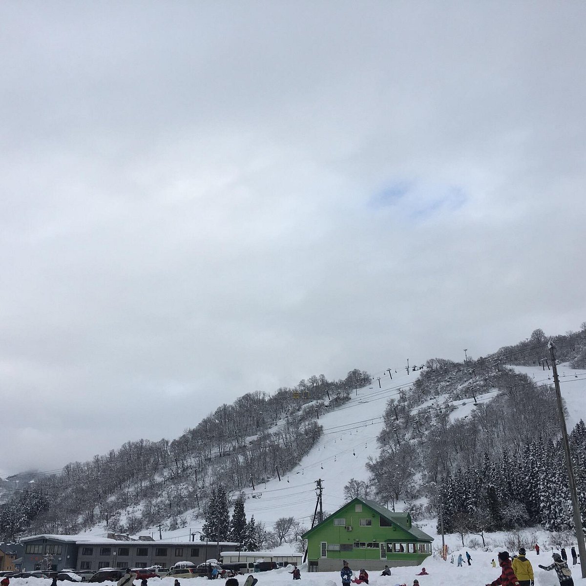 Nakazato Snow Wood in Japan - a group of people skiing down a snow covered slope.