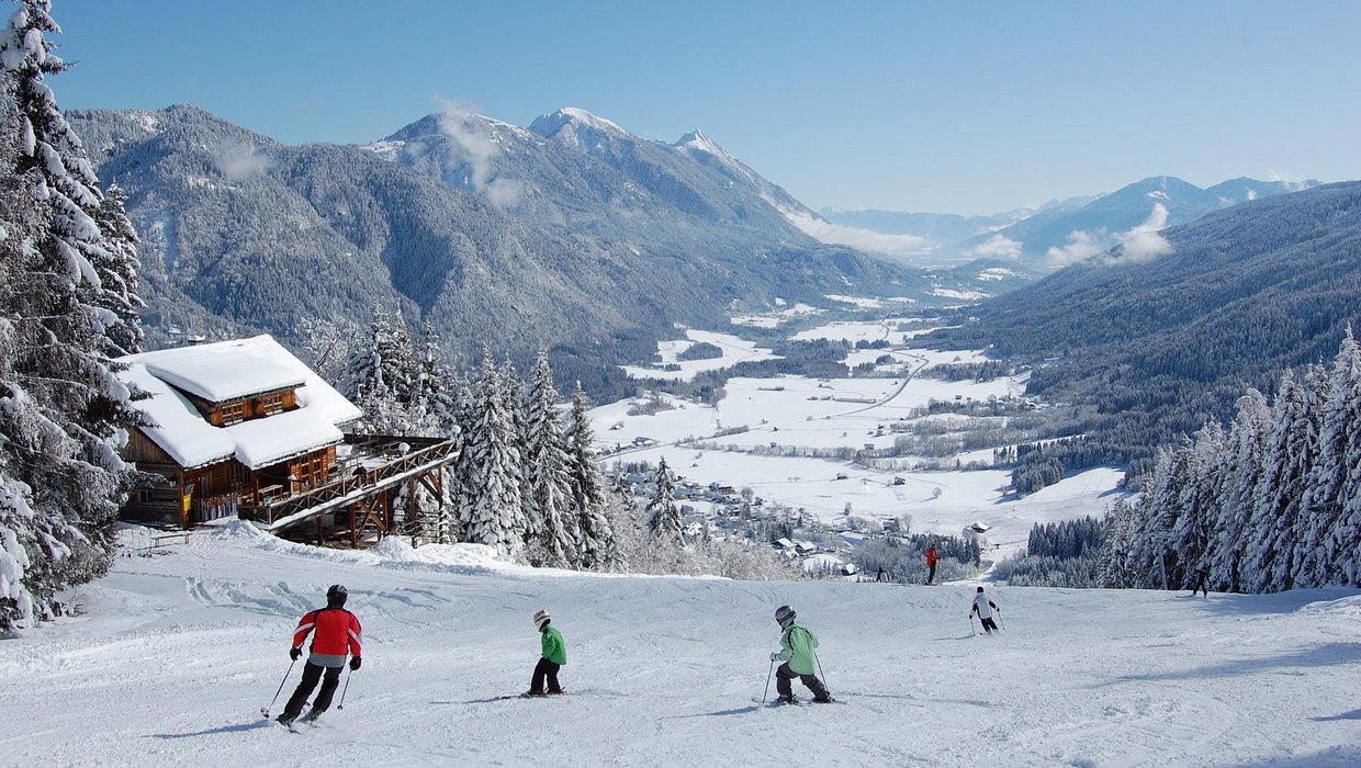 Weissbriach in Austria - a group of people skiing down a snowy slope.