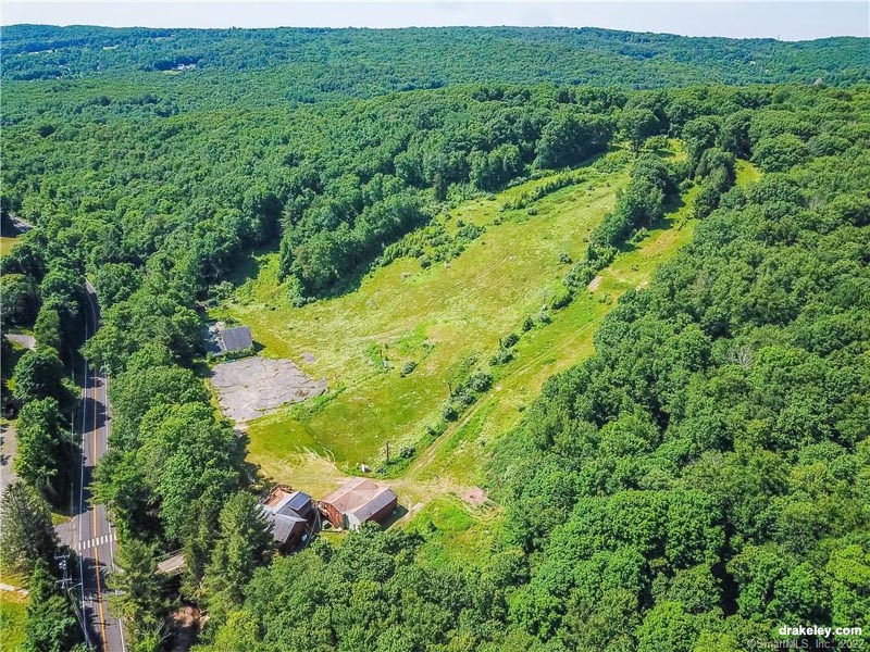 A charming chalet nestled in Woodbury, Connecticut, with a beautiful backdrop of a mountain. The nearby ski resort and lodge add to this winter retreat's allure. A serene lake can be found nearby, enhancing the peaceful setting.