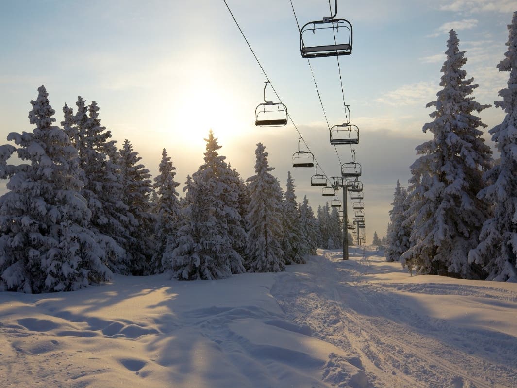 A picturesque winter scene at a ski resort in Woodbury Connecticut featuring a ski lift against the backdrop of a beautiful chalet illustrating the thrill of winter sports.