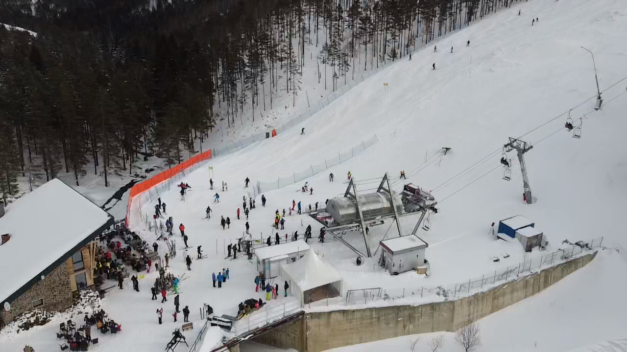 Crni Vrh in Serbia - a group of people standing on top of a snow covered slope.