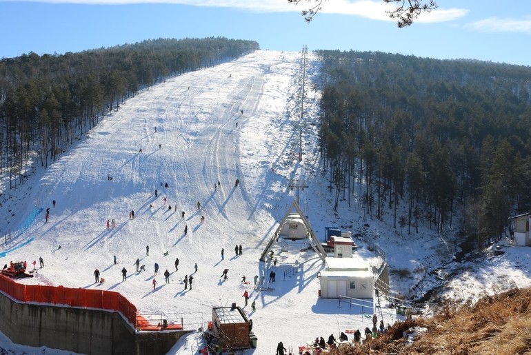 Crni Vrh in Serbia - a ski slope with people skiing down it.