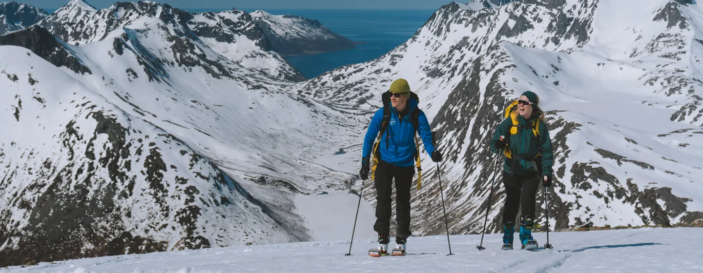 Tromsø in Norway - two people walking up the side of a mountain.