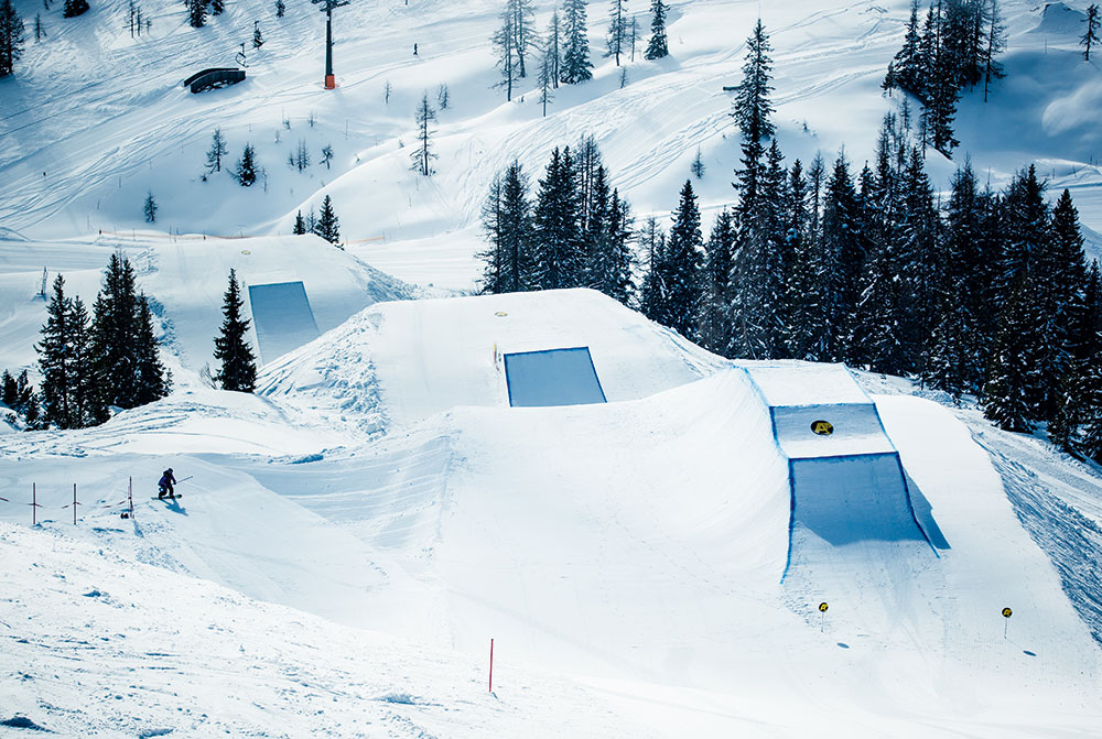 Salzbuger Sportwelt -Amade in Austria - a man riding a snowboard down a snow covered slope.