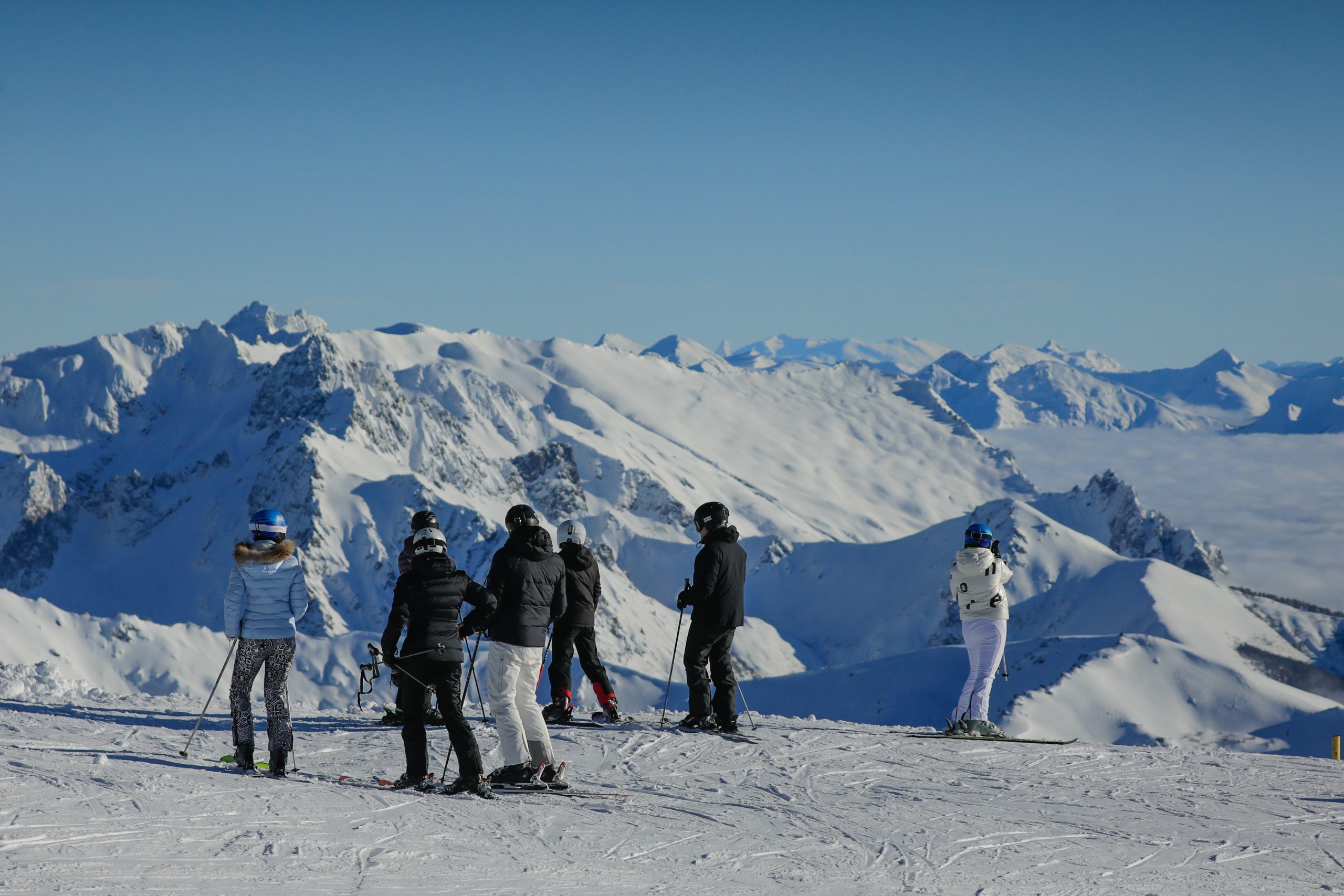 A picturesque scene at the Catedral Alta Patagonia ski resort in Argentina featuring a charming chalet a dynamic winter sports scene with people engaged in skiing amid the pristine snow-covered landscape.