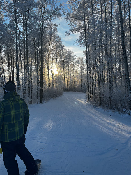 Winter sports scene at Duck Mountain, Kamsack in Saskatchewan, Canada featuring a scenic snowy landscape, a charming chalet in the distance, and a skier gliding across the pristine snow.