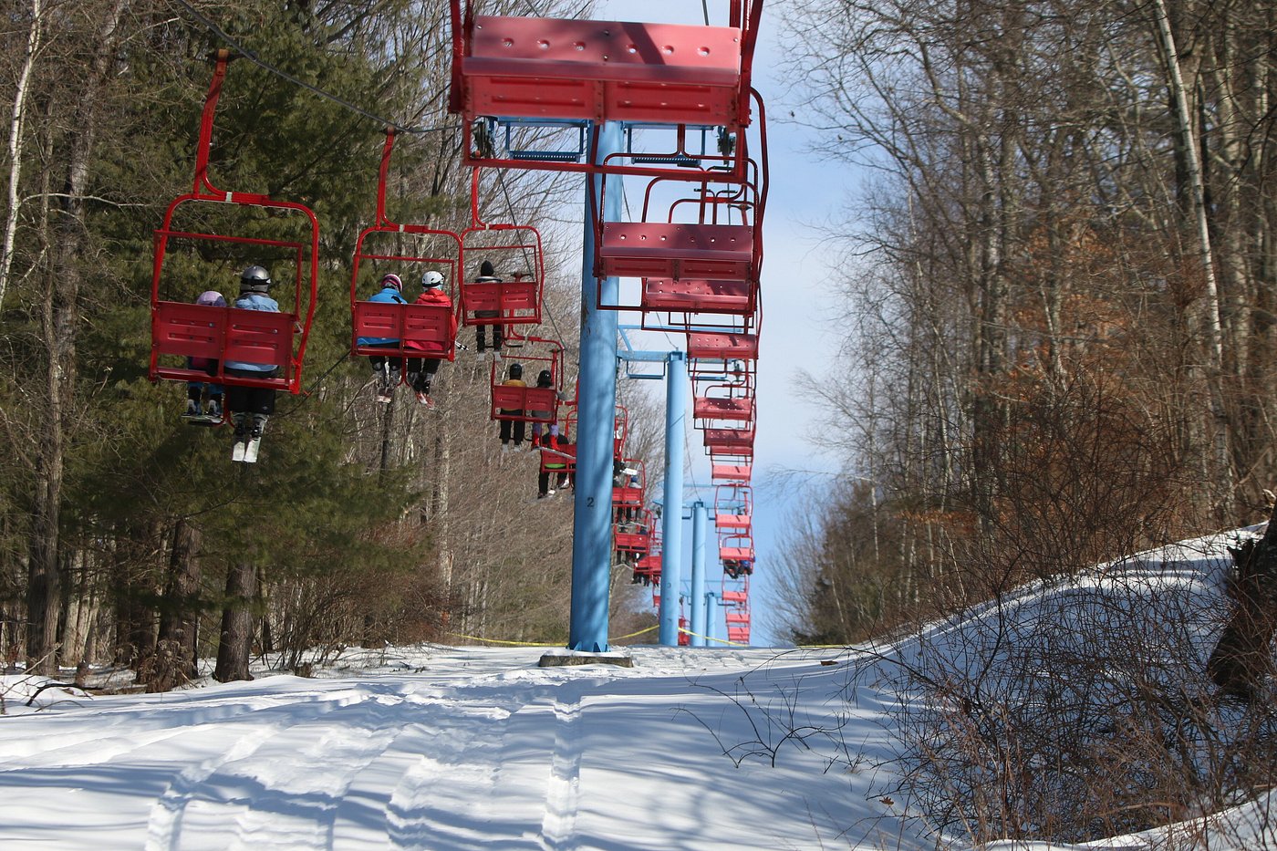 A lively scene at Villa Roma in The Catskills New York featuring a ski lift ascending the snowy mountainside as winter sports enthusiasts enjoy the ski resort.