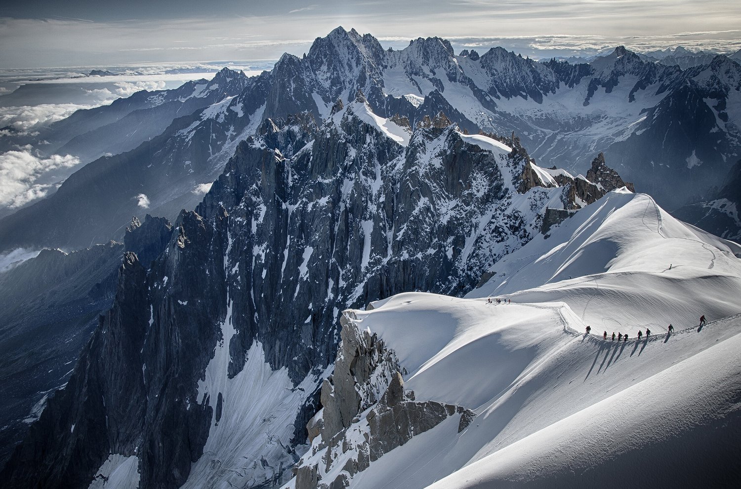 Aiguilles in France - a group of people climbing a snowy mountain.