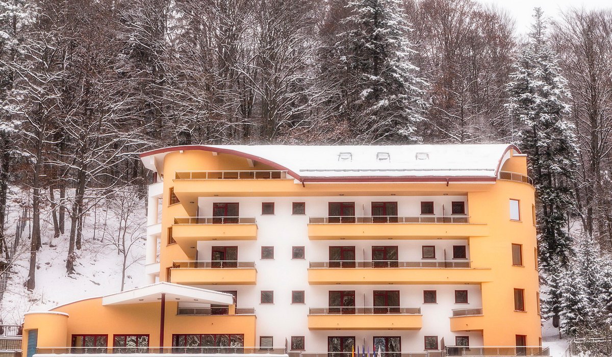 Nemira – Slănic-Moldova in Romania: a yellow building with snow on the ground.