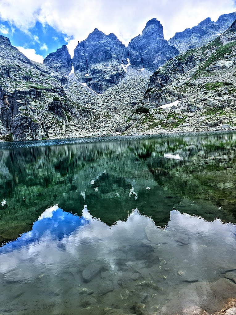 Malyovitsa in Bulgaria - a lake in the mountains with mountains in the background.