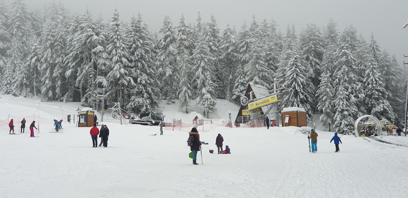 Malyovitsa in Bulgaria - a group of people skiing down a snow covered slope.