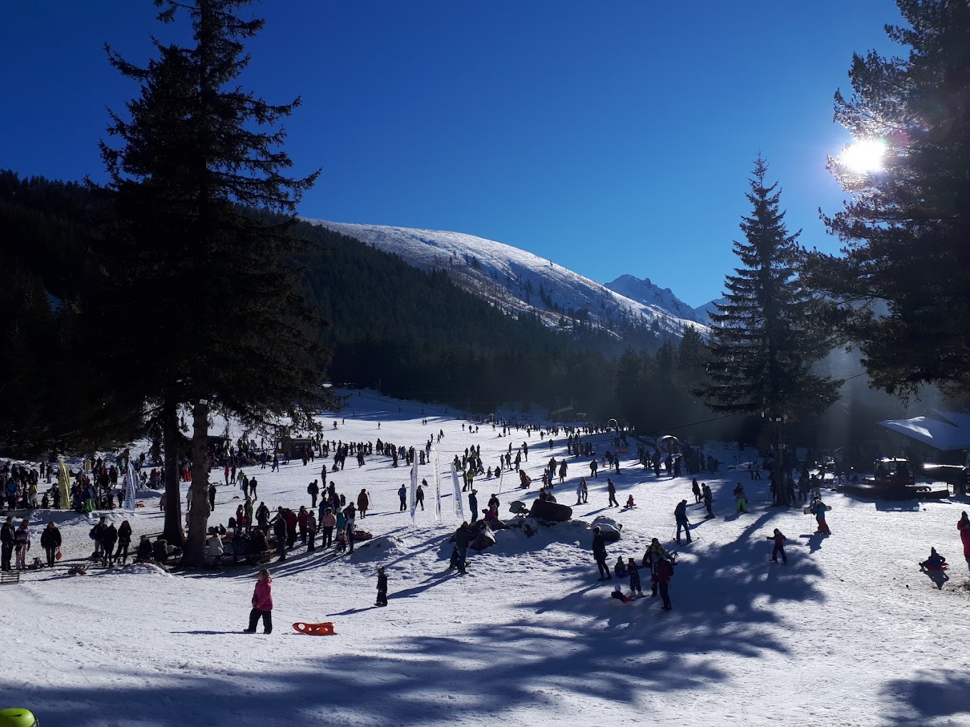 Malyovitsa in Bulgaria - a group of people skiing down a snow covered slope.