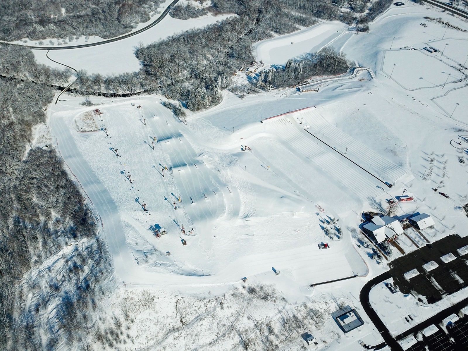 Winter sports scene at The Rock Snowpark in Wisconsin, featuring a ski resort with a ski lift and snow-covered slopes.