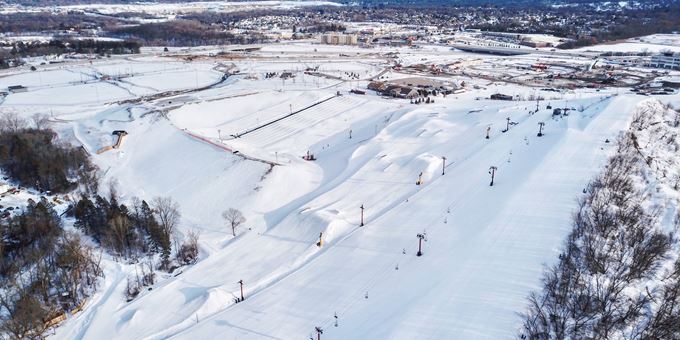 Winter sports enthusiasts enjoy a day at The Rock Snowpark in Wisconsin, USA, complete with snow-covered slopes and picturesque winter scenery of the ski resort.