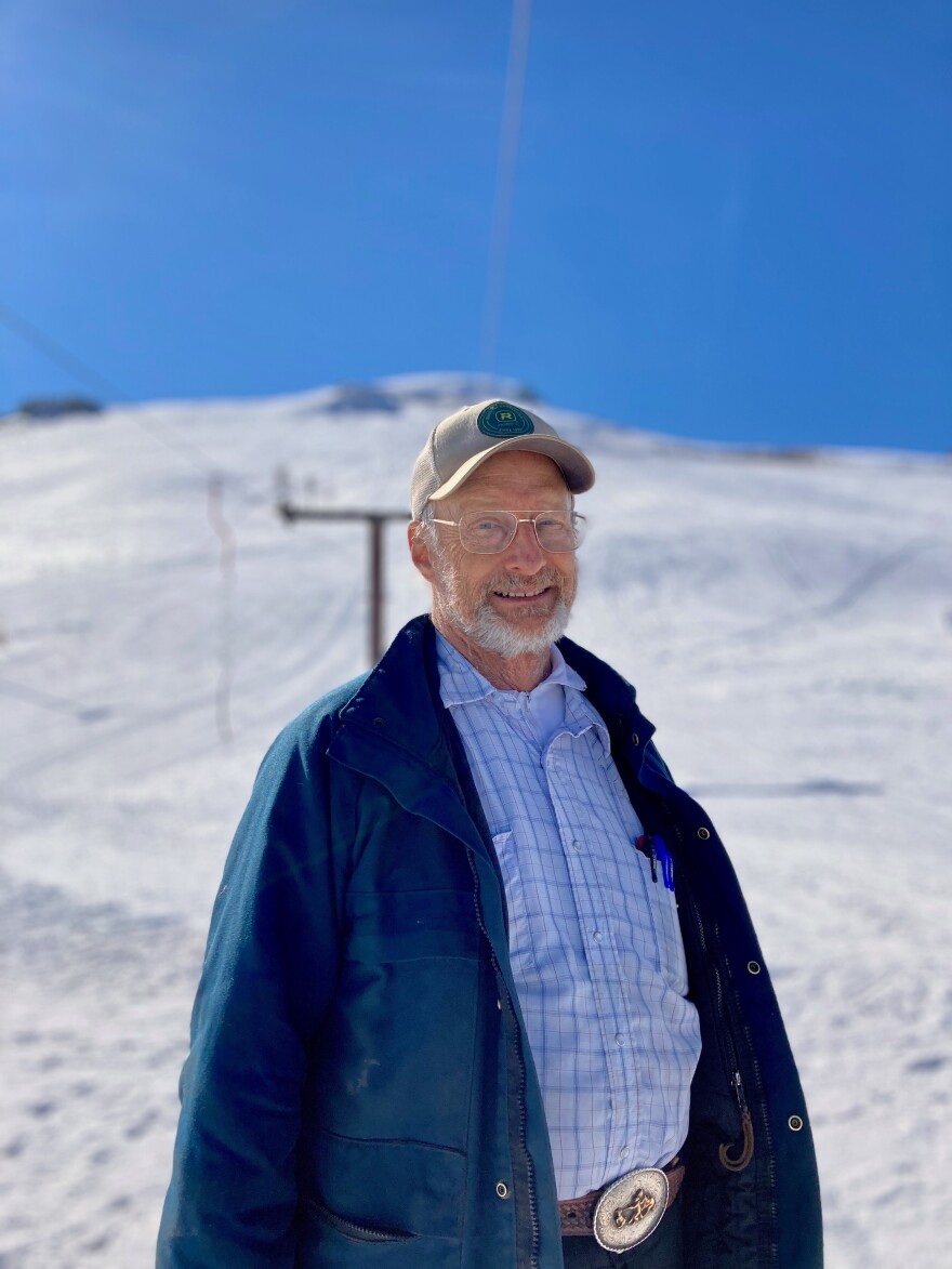 Blizzard Mountain in USA - a man in a blue jacket and hat standing in the snow.