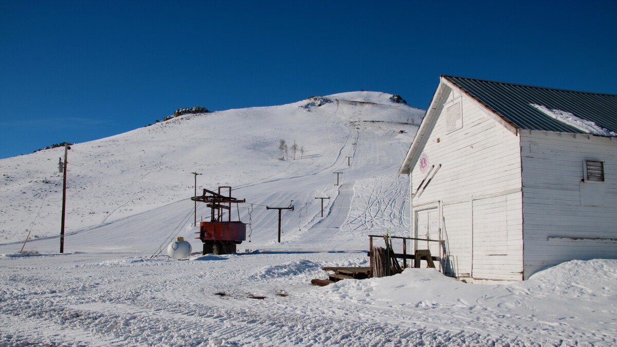 Blizzard Mountain in USA: a small white building sitting on top of a snow covered hill.