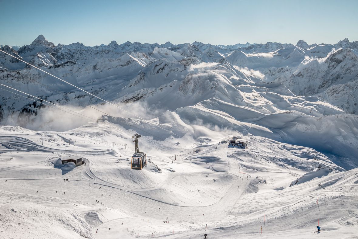 Oberjoch – Iseler in Germany - a ski slope with snow covered mountains in the background.