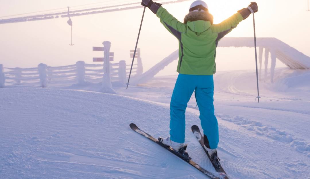 A bustling winter sports scene at Sunrise Park in Arizona USA featuring a skier racing down the snow-covered slopes a ski lift in operation and a hint of a snowboarder sharing the same mountain landscape.