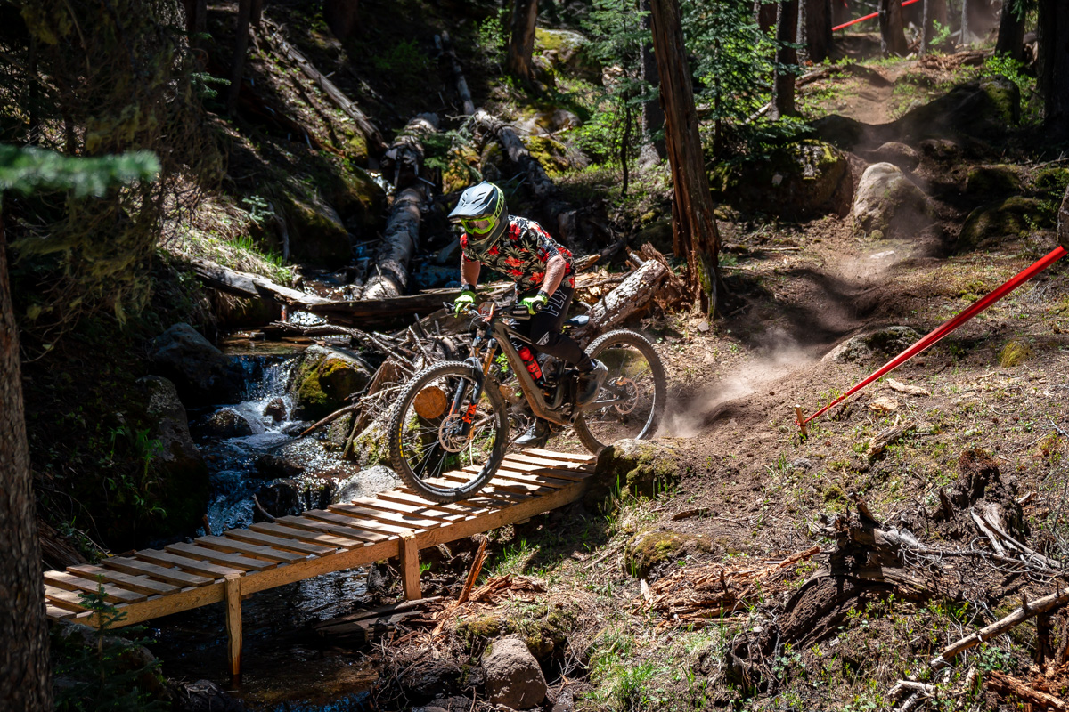 Sunrise Park in USA - a man riding a mountain bike over a wooden bridge.