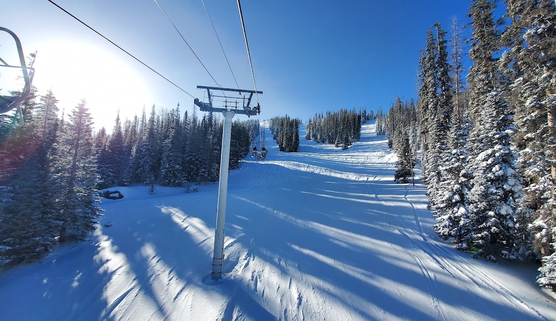 A lively winter sports scene at Sunrise Park Arizona showing a ski lift transporting eager skiers up the snow-covered slopes at the popular ski resort.