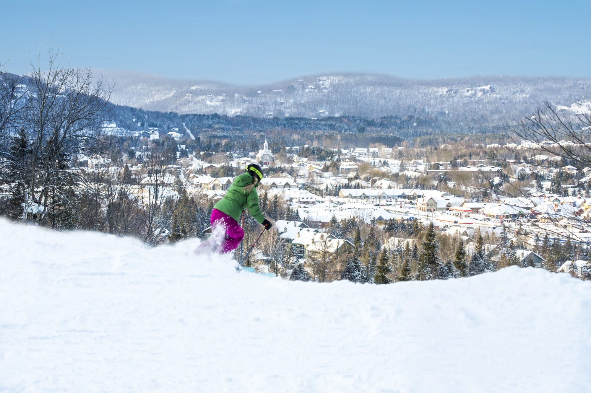 Sommet Saint-Sauveur in Canada - a person on a snowboard going down a hill.