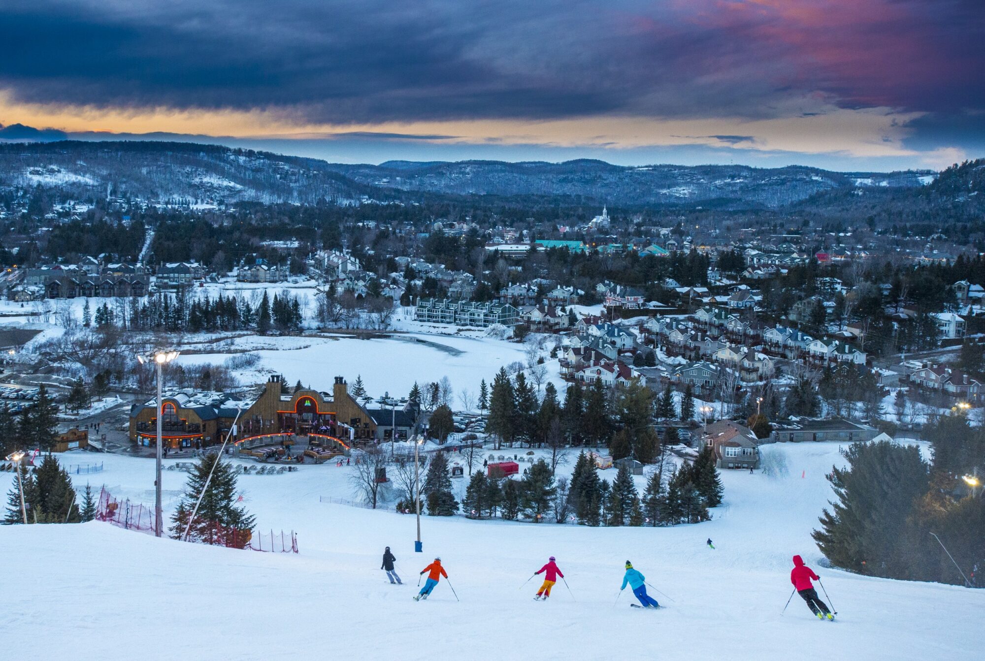 Sommet Saint-Sauveur in Canada - a group of people skiing down a hill.