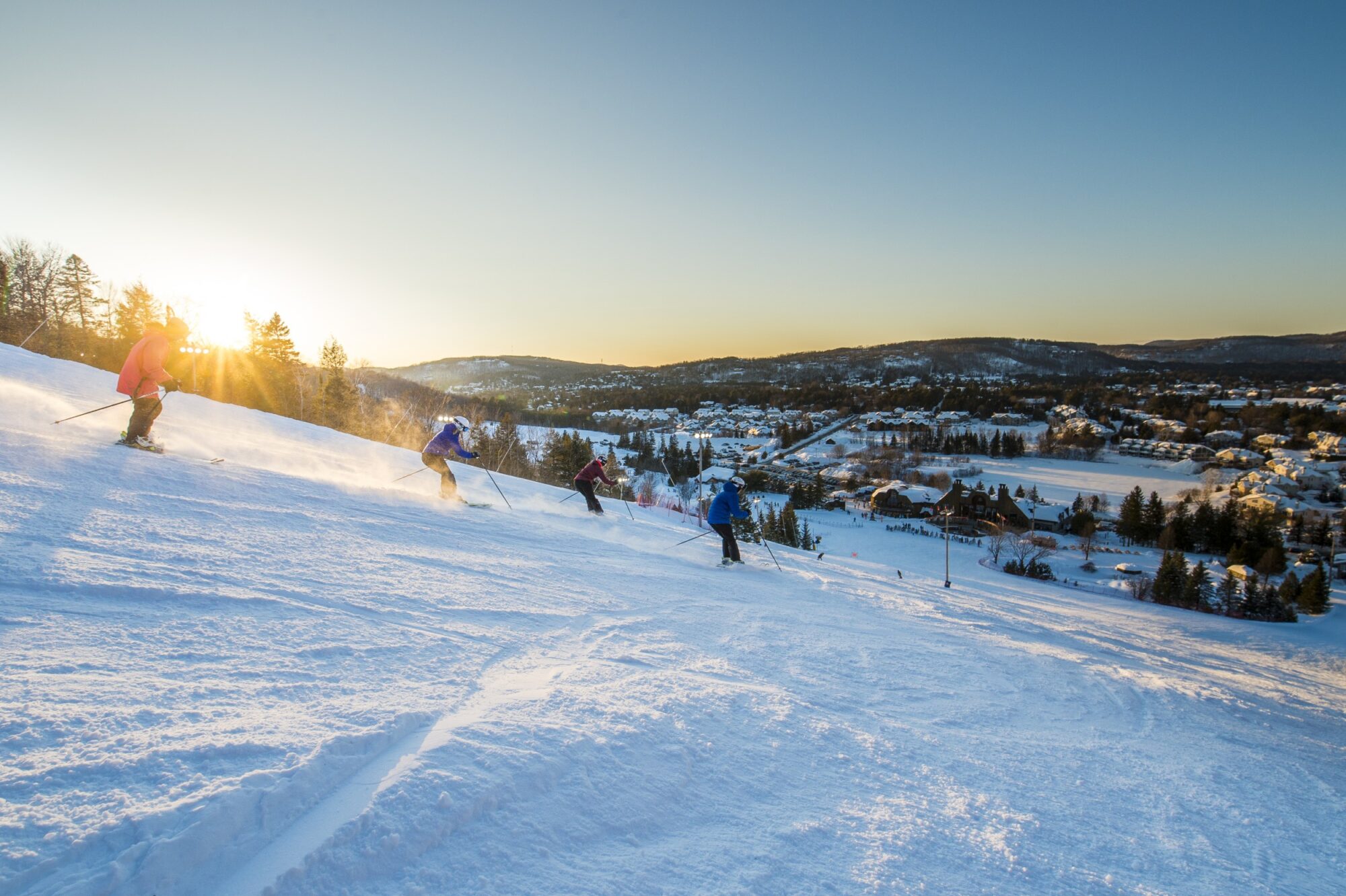 Sommet Saint-Sauveur in Canada - a group of people skiing down a snowy hill.