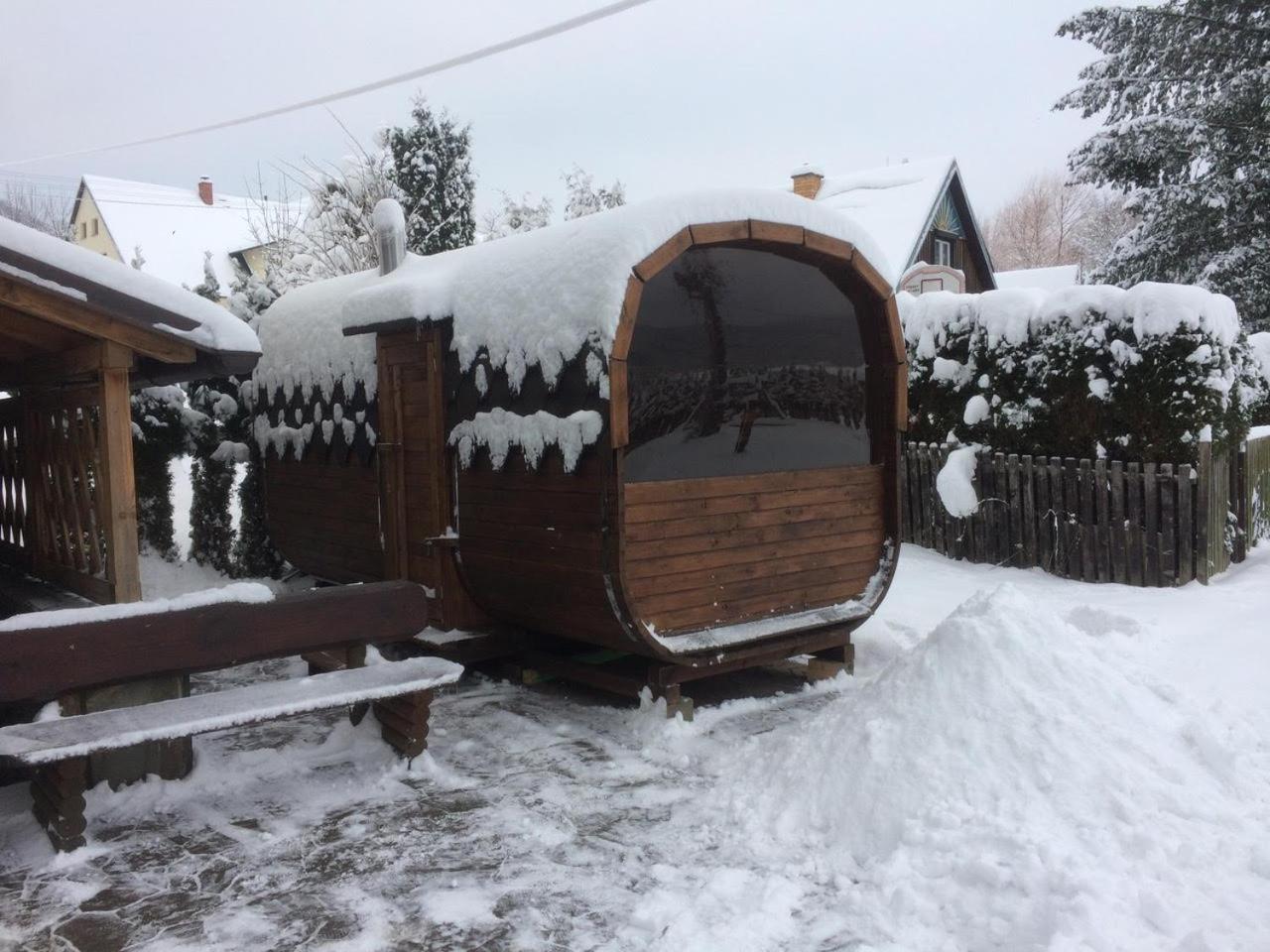 Ski center Miroslav in Czech Republic - a wooden bench covered in snow next to a house.