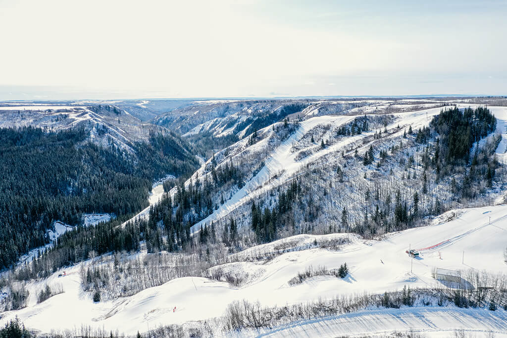 Image of a stunning winter panorama at Fairview Ski Hill in Northern Alberta, Canada. Scene includes snow-covered slopes at a ski resort frequented by winter sports enthusiasts.