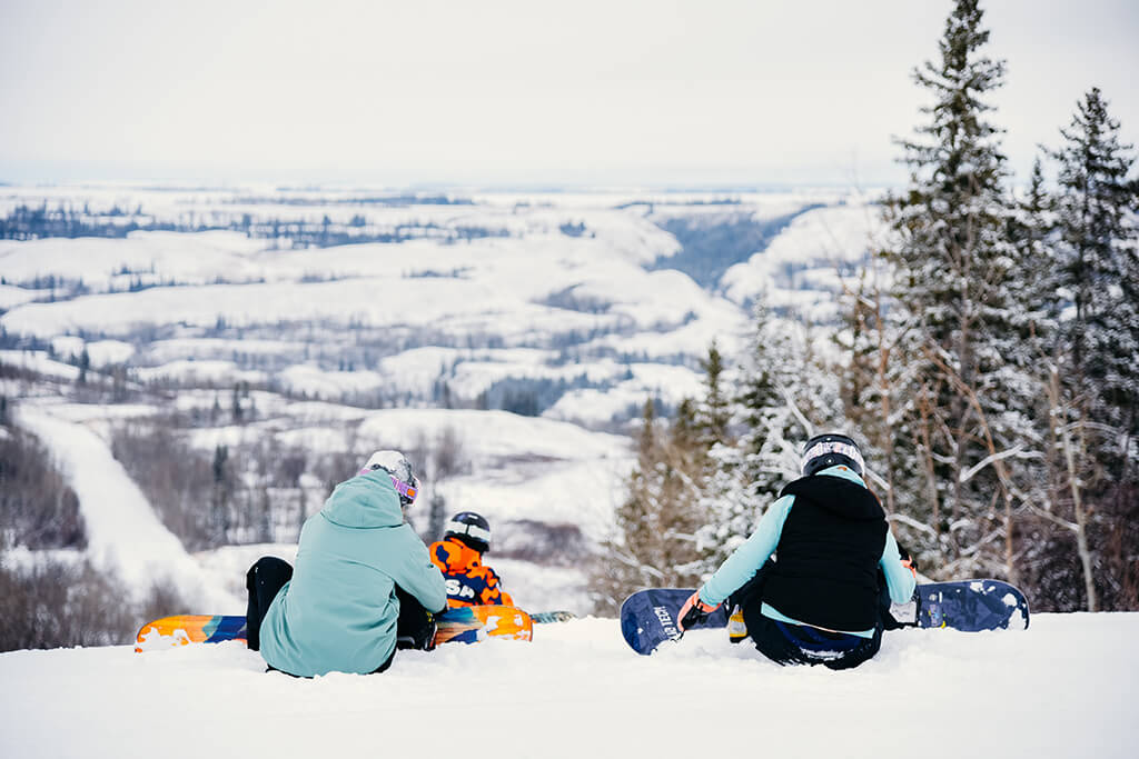 A family enjoying skiing on a picture-perfect day at the Fairview Ski Hill in Northern Alberta Canada immersed in stunning winter scenery.