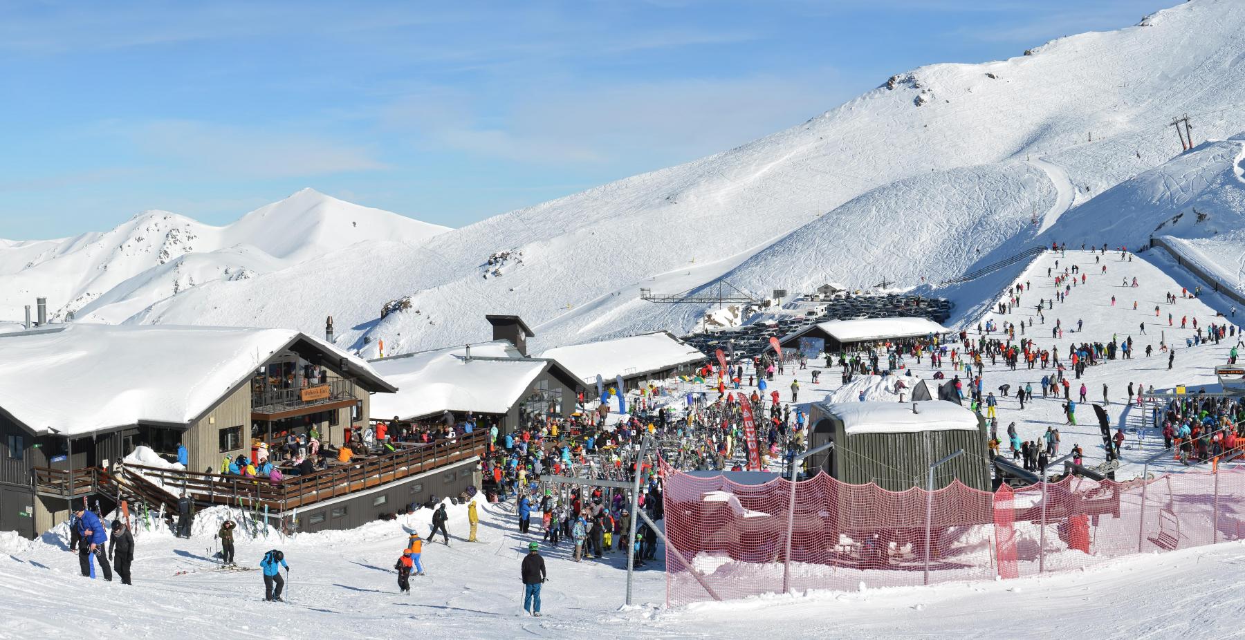 Mt Hutt in New Zealand - a group of people skiing down a snowy slope.