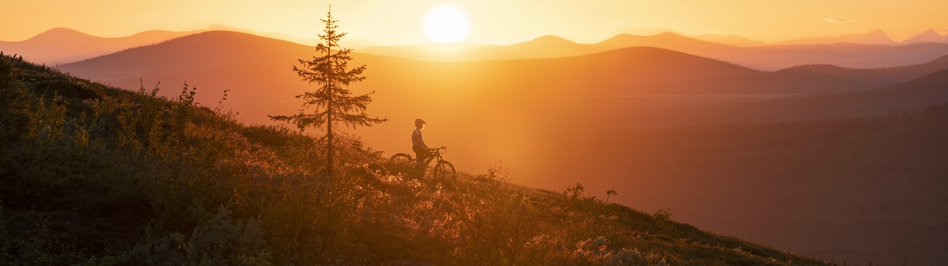 Dundret Lapland – Gällivare in Sweden - a person standing on top of a mountain at sunset.