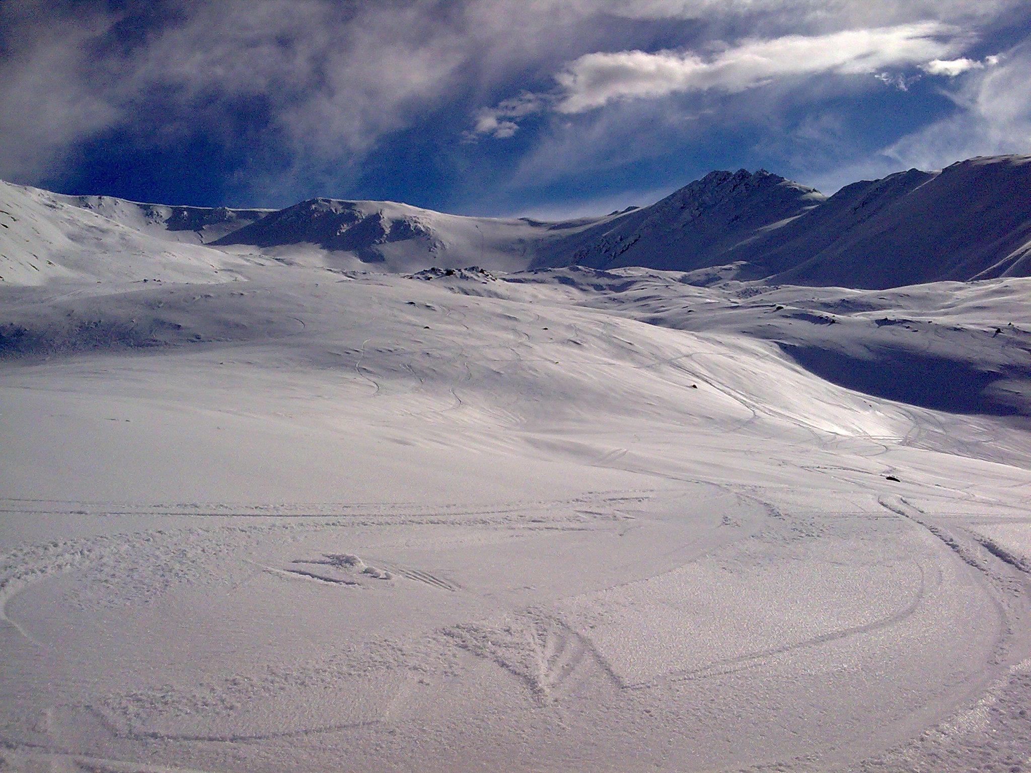 A chalet nestled in the stunning snow-covered slopes of Awakino, Canterbury, New Zealand. A skier navigates the wintry terrain, amplifying the feeling of an active ski resort.