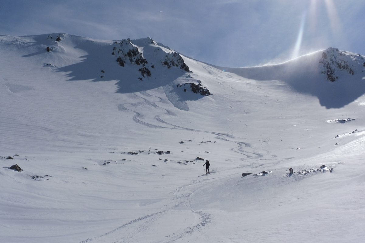 A skier glides downhill in a winter sports scene at the Awakino ski resort in Canterbury New Zealand with a charming chalet and the pristine mountain backdrop adding to the allure.