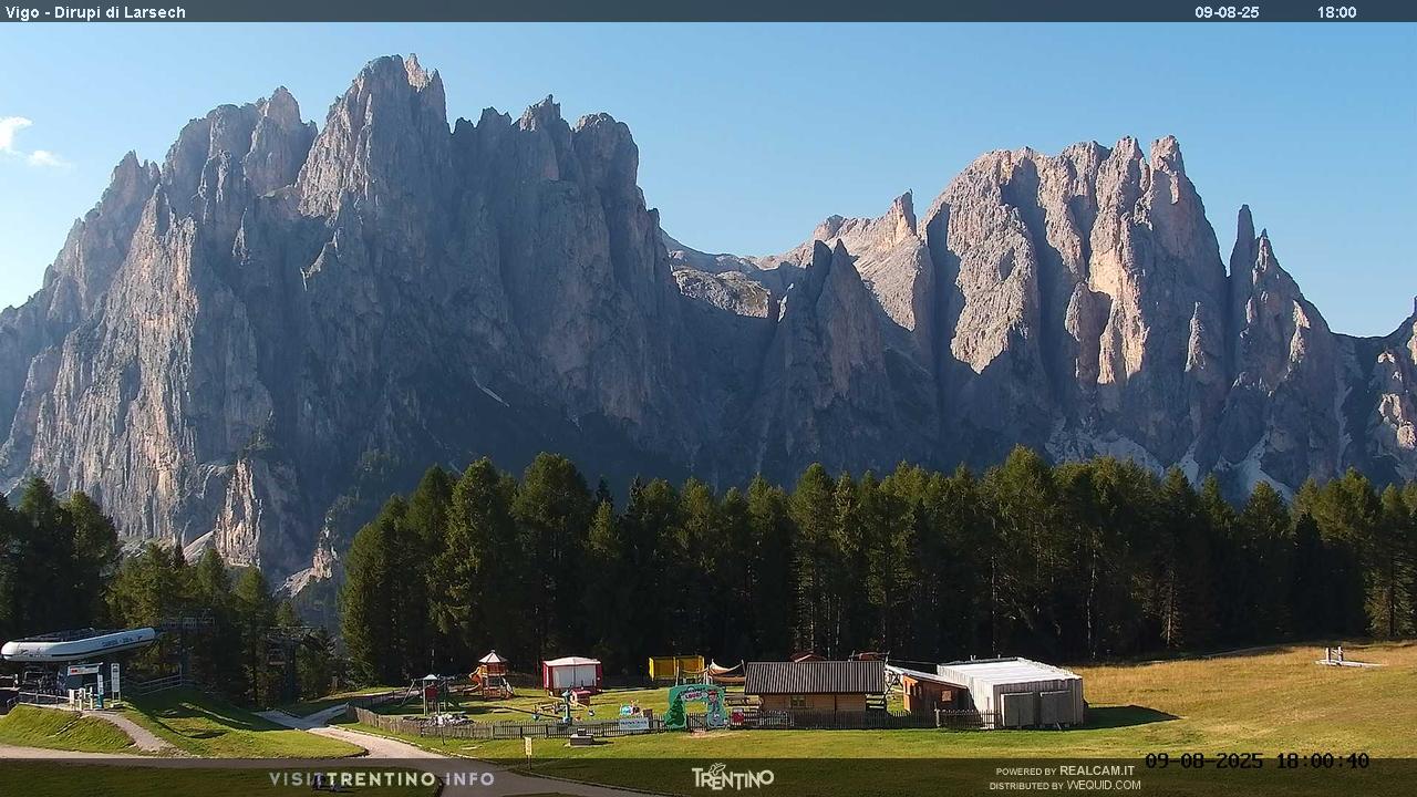 Catinaccio Ciampedie in Italy - the mountains are covered with clouds and trees.