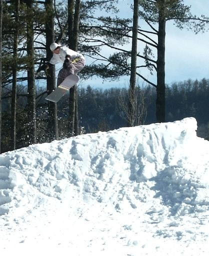 A snowboarder skillfully gliding down the snow-covered slopes of Sapphire Valley, North Carolina. The winter sun illuminates the scenic landscape, creating a breathtaking backdrop.