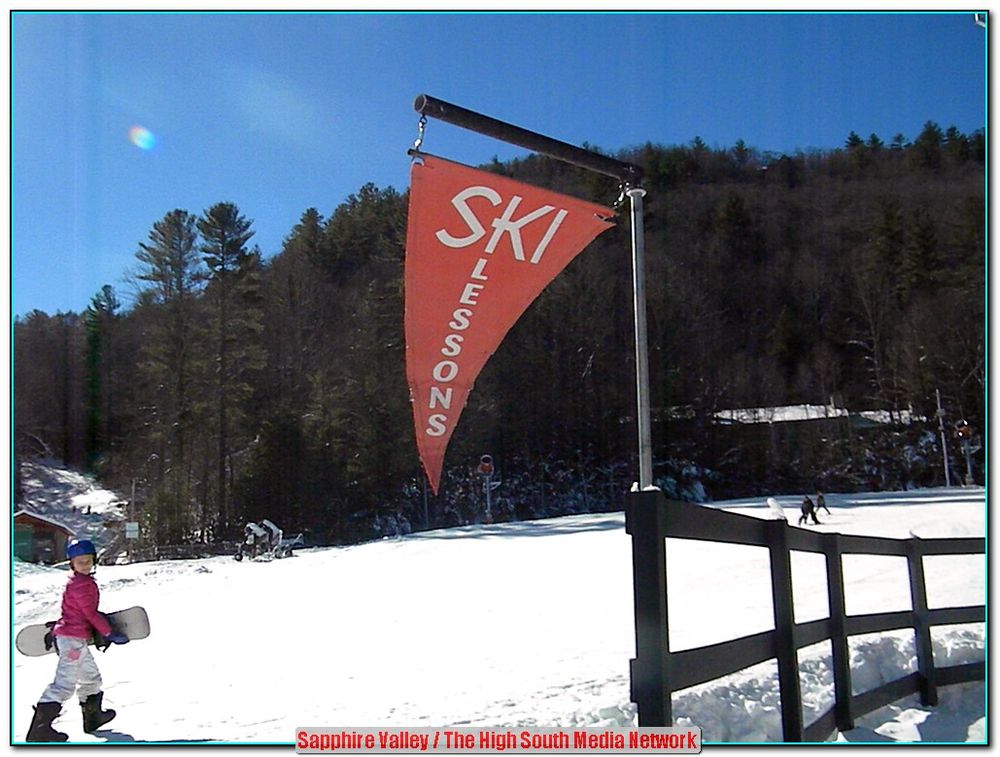 A winter scene at Sapphire Valley ski resort in Sapphire North Carolina featuring a ski lift and a skier enjoying the snowy landscape.