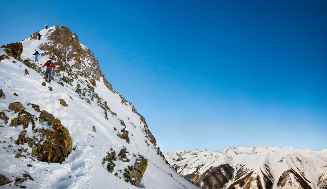 Silverton Mountain in USA - a man climbing up the side of a snowy mountain.