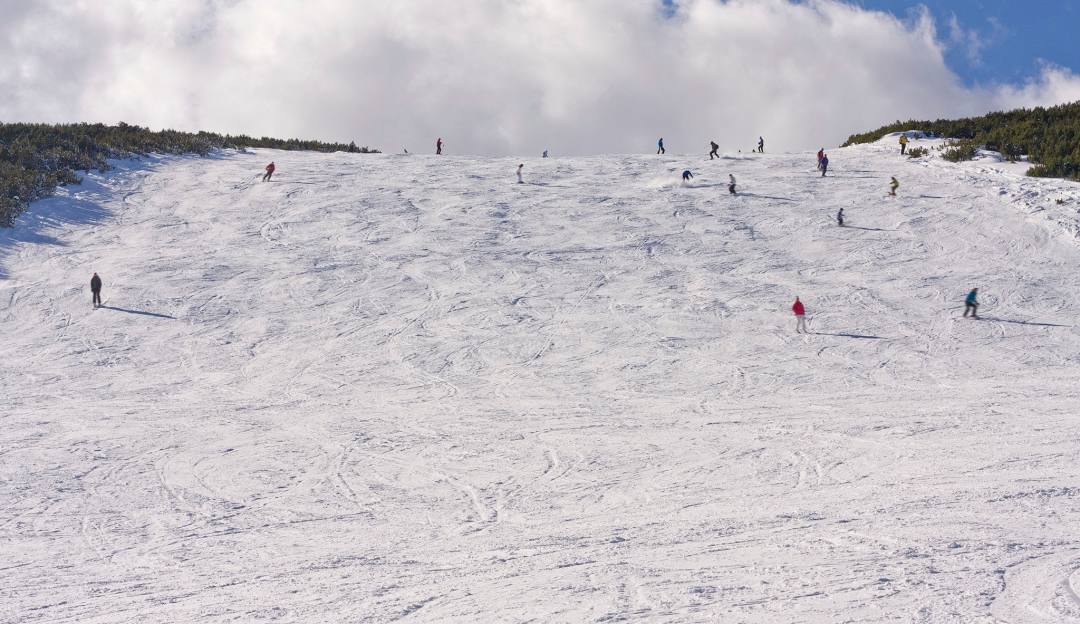 Borovets in Bulgaria - a group of people skiing down a snowy slope.