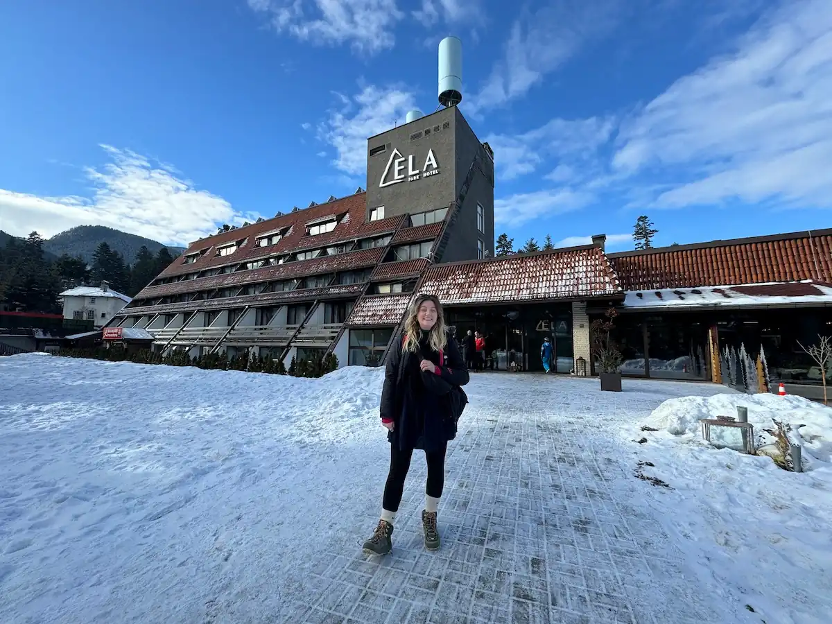 Borovets in Bulgaria: a woman standing in the snow outside of a building.