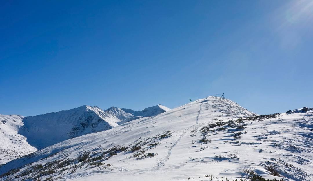 Borovets in Bulgaria - a snow covered mountain with a clear blue sky.