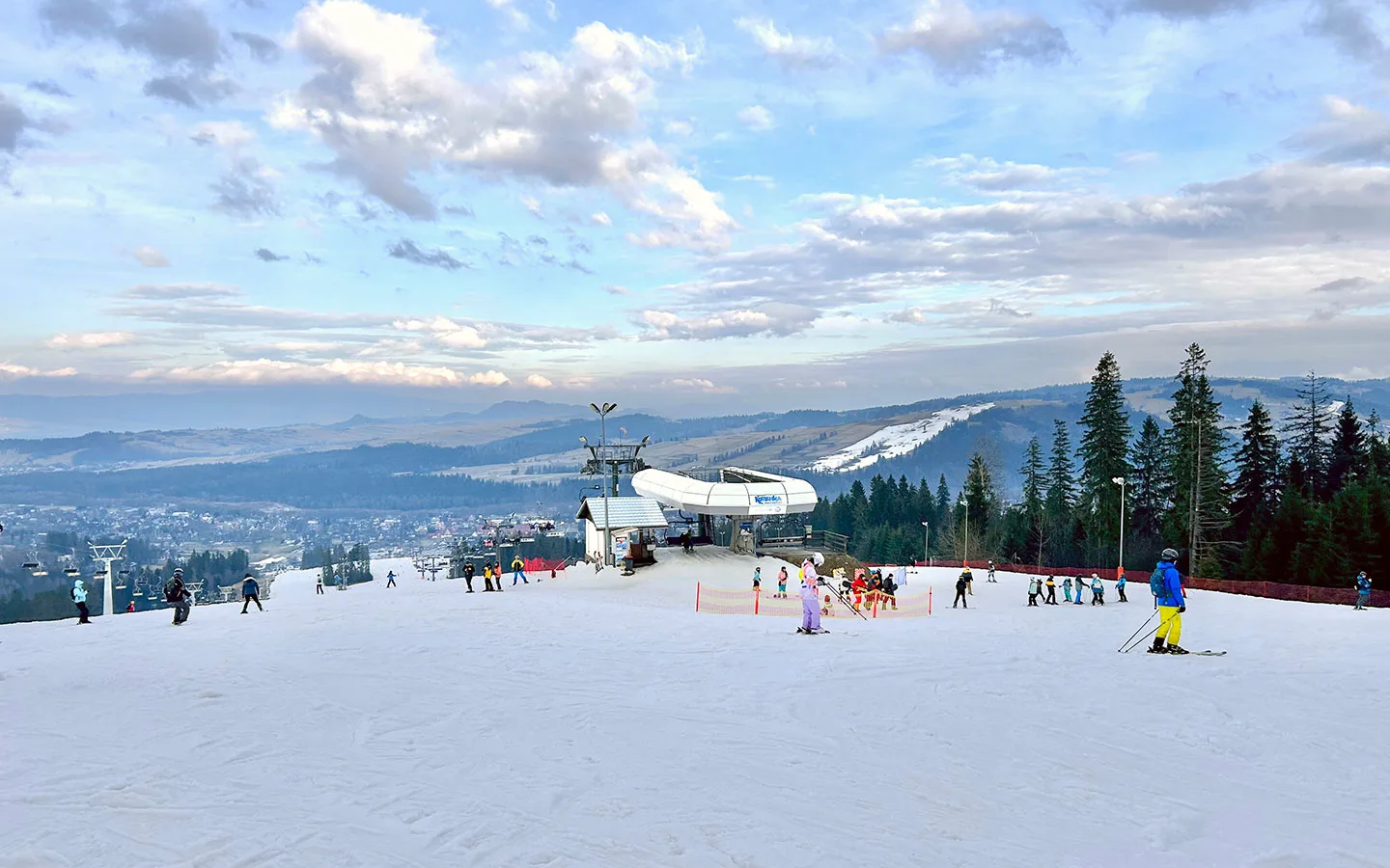 Gubałówka – Zakopane in Poland - a group of people skiing down a snow covered slope.