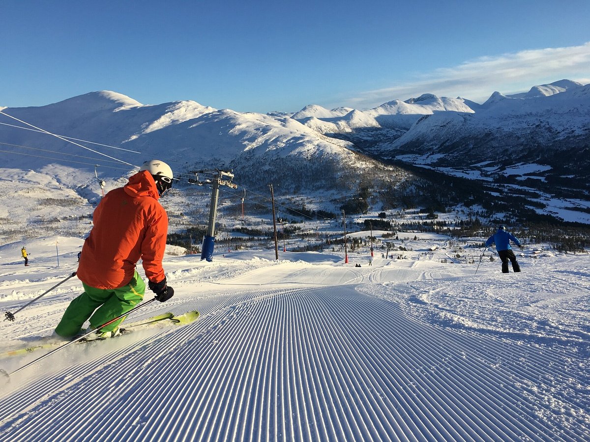 Hornindal in Norway - a person in an orange jacket skiing down a slope.