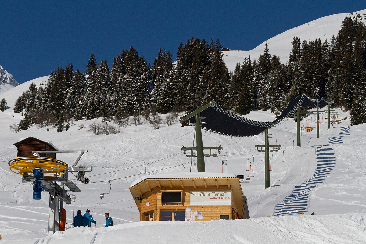 Tenna in Switzerland - a group of people skiing down a snowy hill.