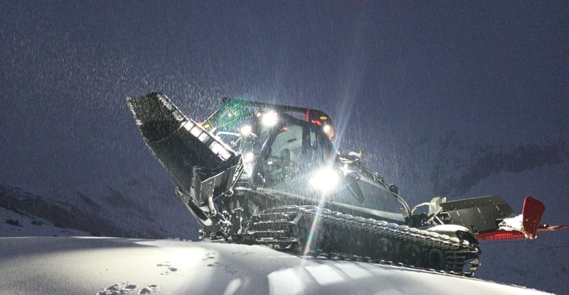 A snowmobile is prominently featured at Meran 2000 in South Tyrol Italy. Winter sports enthusiasts including a skier can be seen enjoying the snowy scene. A ski lift ascends in the background at this vibrant ski resort.