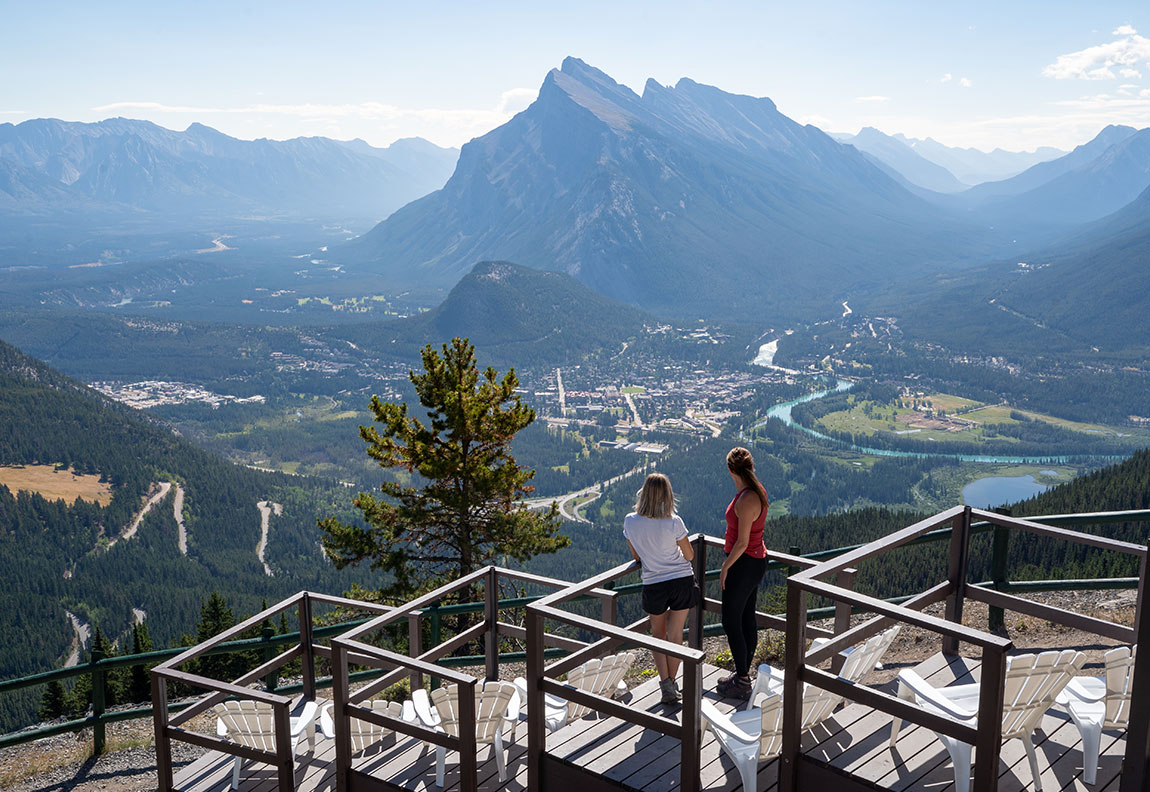 Mt Norquay – Banff in Canada - a couple of people standing on top of a mountain.