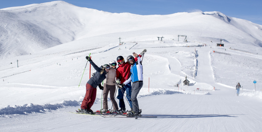 A group of people including a family enjoying a skiing session in Lachtal Murtal Austria. A Chalet is visible in the winter sports scene.