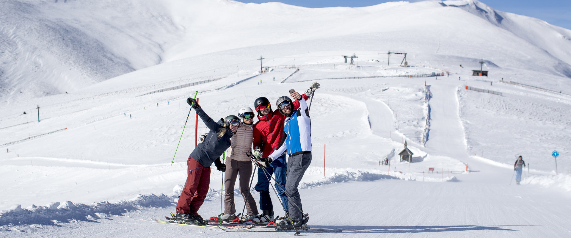 A group of people including a family enjoying a vibrant winter sports scene in Lachtal Murtal Styria Austria. They're skiing near a charming chalet part of a winter sports centre.