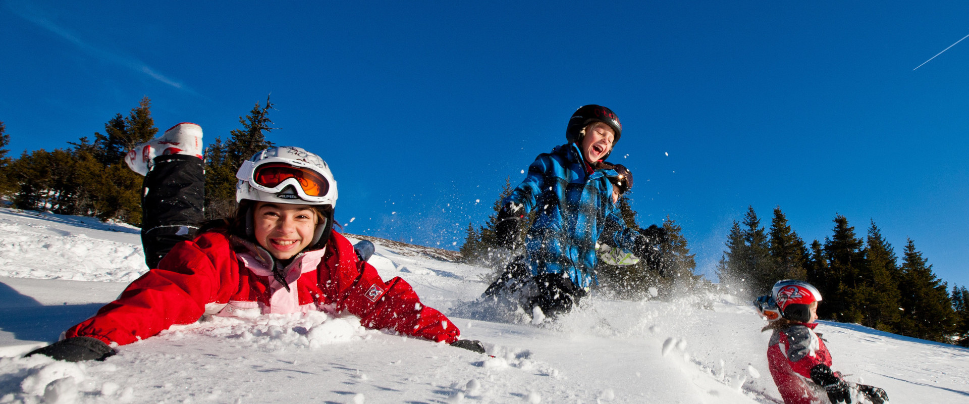 A vibrant winter sports scene in Lachtal Styria Austria featuring a snowboarder and skier in action. The picturesque winter sports centre buzzes with families enjoying skiing on the snow-covered slopes.