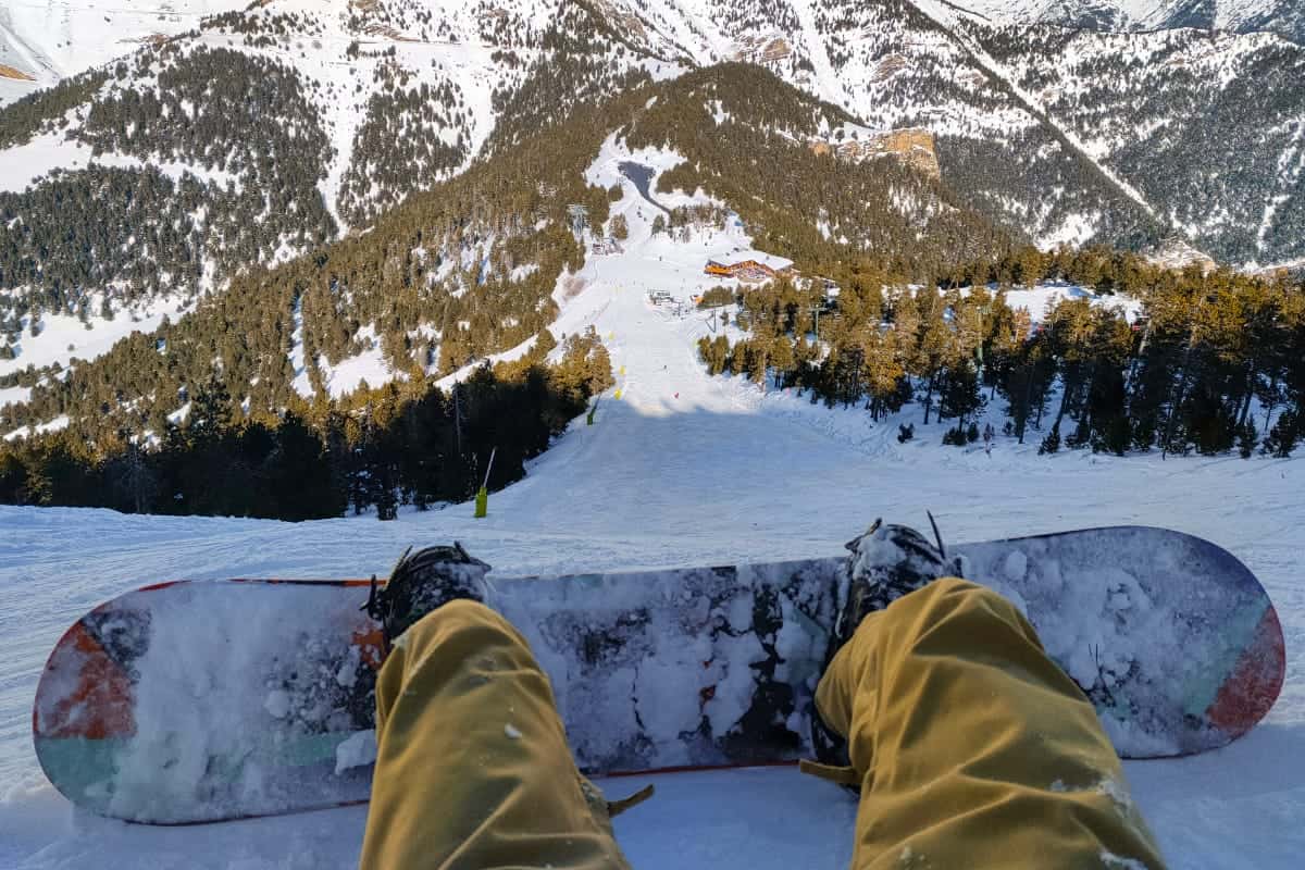 Pal Arinsal – La Massana in Andorra - a person's feet on a snowboard in the snow.